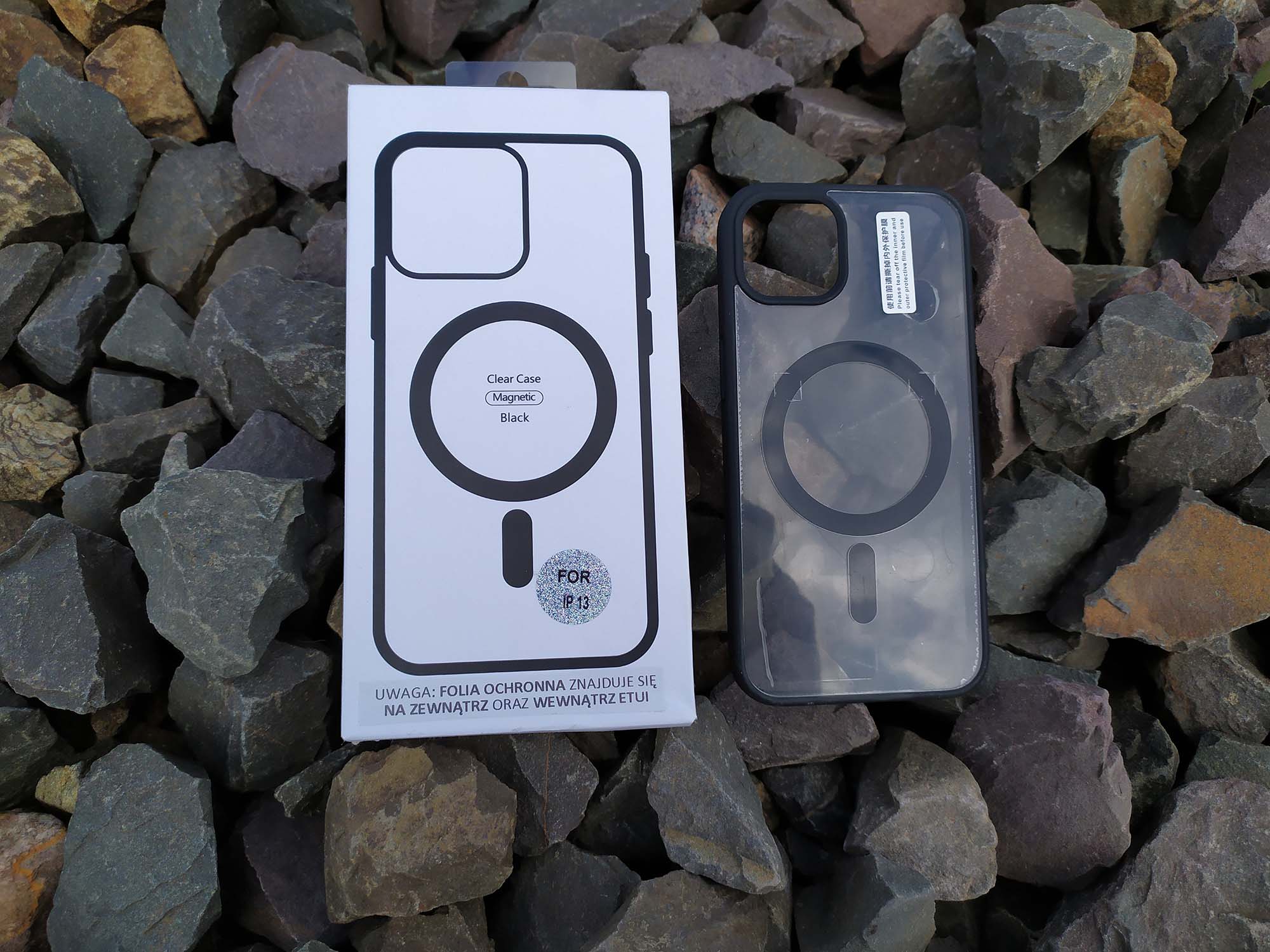 Etui z serii Clear+ Case z MagSafe z pudełkiem w  scenerii kamiennej.